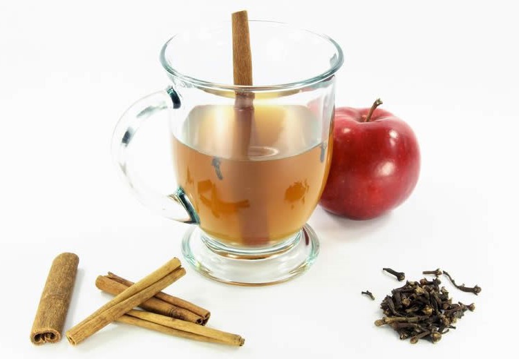 Cider in a glass with apple and Cinamon at the side